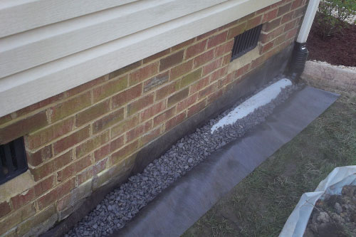 a french drain along the foundation of a house for water and moisture control by gilbert and son class A contractor in chesapeake, virginia