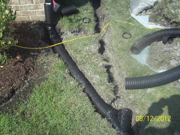 a french drain in yard to divert water from house designed and installed by gilbert and son a foundation mold and moisture company
